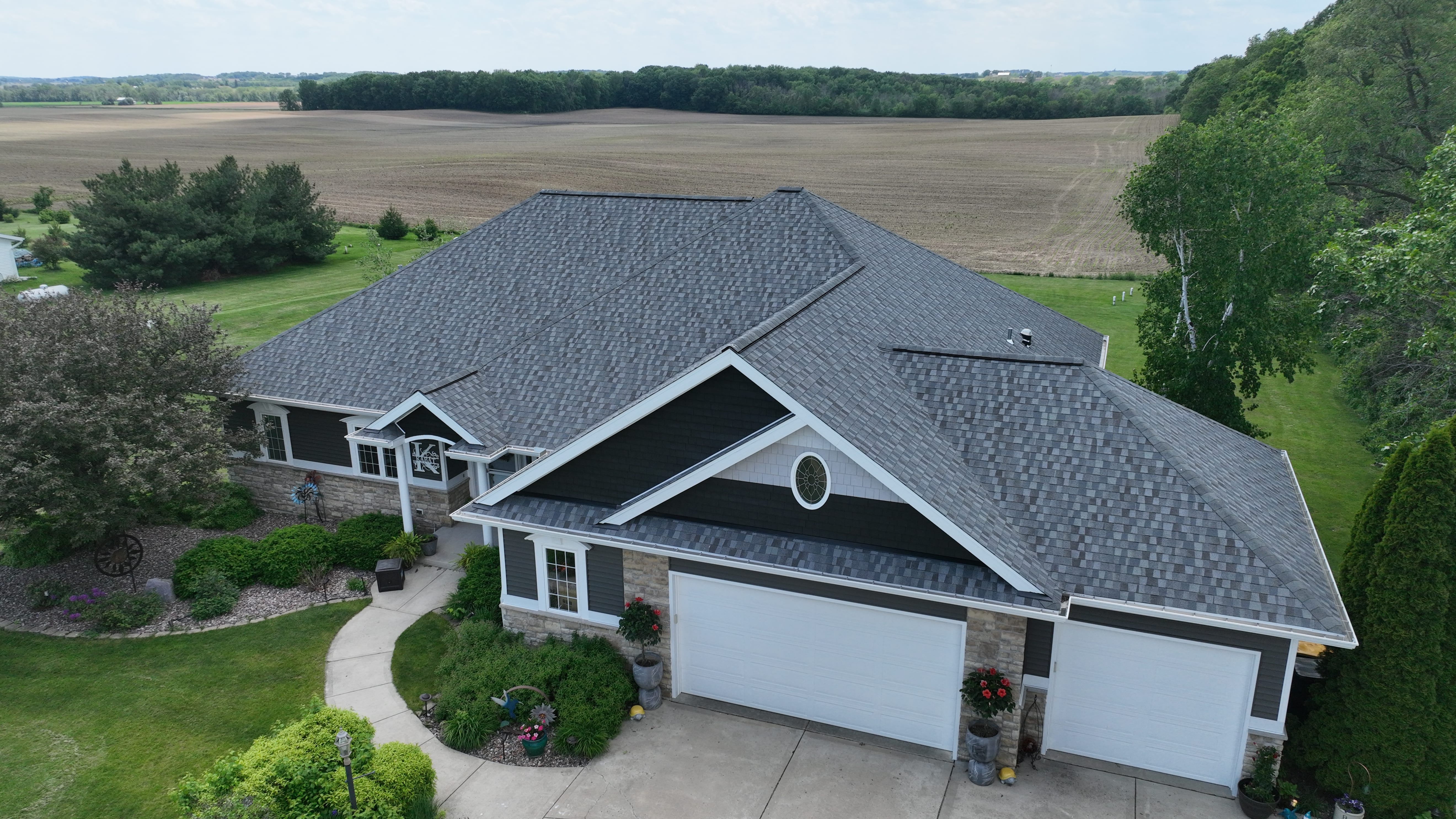 Traditional Iowa family home with a freshly installed asphalt shingle roof and seamless gutters